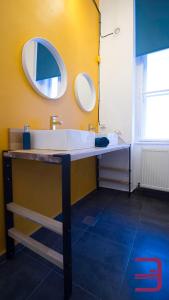 a bathroom with a sink and a mirror at InVerve Hostel in Timişoara