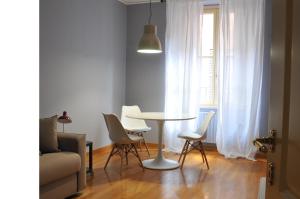 un soggiorno con tavolo, sedie e finestra di Residenza Fiori Oscuri a Milano