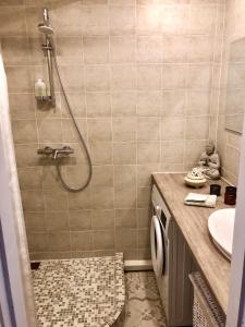 ein Bad mit einer Dusche und einem Waschbecken in der Unterkunft Wind Rose apartment in Kuressaare