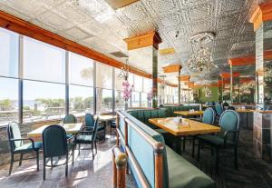 a restaurant with tables and chairs and large windows at Ocean Annie's Resorts in Myrtle Beach