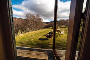 a door with a view of a field with a picnic table at Howe of Torbeg in Ballater