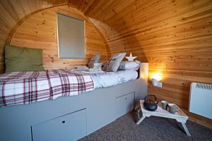 a bedroom with a bed in a wooden cabin at Howe of Torbeg in Ballater
