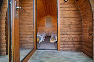 a room with two beds in a wooden cabin at Howe of Torbeg in Ballater