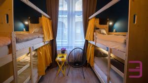 a room with three bunk beds with yellow curtains at InVerve Hostel in Timişoara