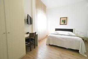 a bedroom with a bed and a desk and a television at Fra'iMari in Gallipoli
