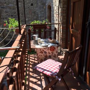 a table and a chair sitting on a balcony at Casa Mary apartments in Tignale