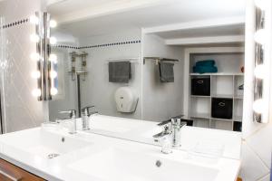 een badkamer met een witte wastafel en een spiegel bij Escale Au Soleil Hôtel et Appart in Saint-Aygulf