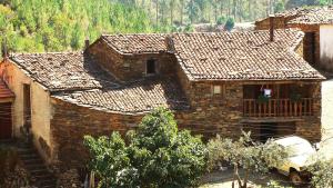 an old house with a car parked in front of it at A Casa da Natália in Alvares
