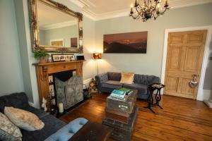 a living room with a couch and a mirror at Treherne House & The Malvern Retreat in Great Malvern +56 photos