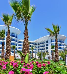 un hôtel avec des palmiers et des fleurs devant lui dans l'établissement Sultan of Dreams Hotel & Spa, à Kızılot