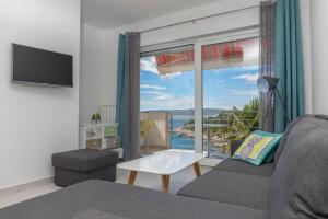 ein Wohnzimmer mit Couch und großem Fenster in der Unterkunft Apartments Zorica in Dramalj