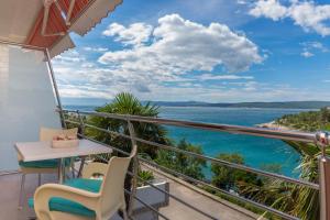 a balcony with a table and chairs and a view of the ocean at Apartments Zorica in Dramalj
