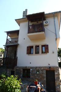 a white building with a balcony on the side of it at Guesthouse Xenioti in Tsagarada