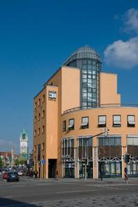 
a large building with a clock on the front of it at Hotel Theresientor in Straubing
