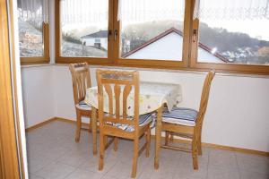 a dining room with a table and two chairs and a window at Ferienwohnung im Hainertal in Heigenbrücken