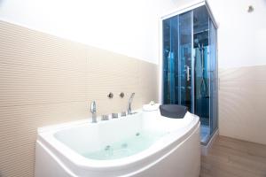 un ampio bagno bianco con vasca e doccia di Fior di Loto Sweetness a Cagliari