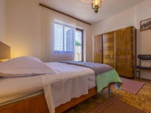 a bedroom with a large bed and a window at Apartments Meri in Dramalj