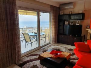 sala de estar con sofá rojo y ventana grande en Christos house-- Comfortable apartment with great view!, en Kavala