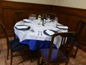 una mesa con copas de vino y botellas de vino. en Hostal Restaurante San Poul, en Consuegra