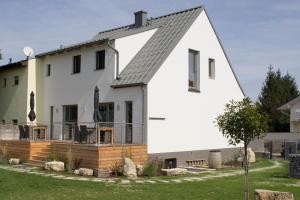 une maison blanche avec un toit noir dans l'établissement Logis 11 Apartments, à Rust