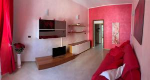 salon z czerwoną kanapą i telewizorem w obiekcie Appartamento La Regina Del Garda w mieście Peschiera del Garda