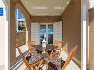 a table and chairs on the balcony of a house at Apartment Color Green in Dramalj +18 photos