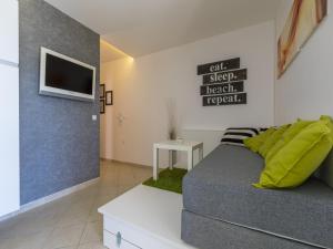 a bedroom with a bed and a tv on a wall at Apartment Color Green in Dramalj