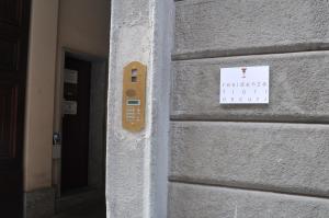 un cartello sul lato di un edificio accanto a una porta di Residenza Fiori Oscuri a Milano