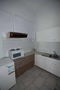 a kitchen with a sink and a stove top oven at Oikeion in Ermoupoli