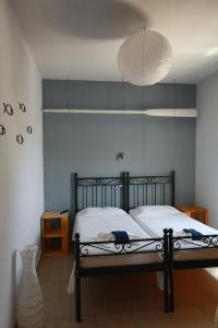 ein Schlafzimmer mit einem Bett und einer Lampe in der Unterkunft Oikeion in Ermoupoli