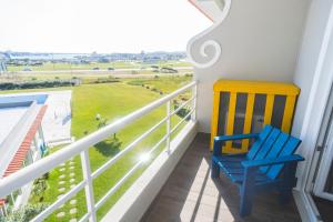 a blue chair sitting on a balcony looking out at a green field at Star inn Peniche in Peniche