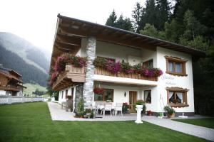 uma casa com uma varanda com flores em Gästehaus Lukasser em Hippach