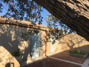 an entrance to a house with a tree in the foreground at Agriturismo Avola Antica in Avola