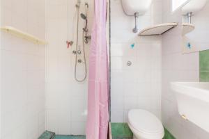 a bathroom with a pink shower curtain and a toilet at Casa Rosa a 50mt dal mare in Torre Santa Sabina