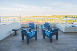 a balcony with four blue chairs and a table at Star inn Peniche in Peniche