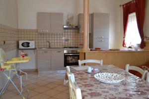 kuchnia ze stołem i krzesłami oraz kuchnia z kuchenką w obiekcie Appartamento Isola D'oro w mieście Piazza Armerina