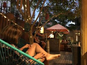 a woman sitting in a hammock outside a store at Backpacker's Hostel Iquique in Iquique