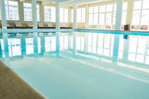 a swimming pool with chairs in a building at Star inn Peniche in Peniche