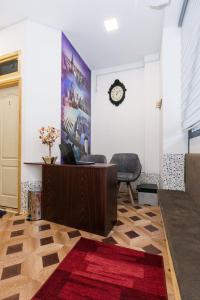 Habitación con escritorio y reloj en la pared en Hostel Put Svile, en Subotica