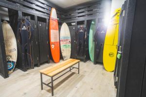 a bench in a room with surfboards on a wall at Star inn Peniche in Peniche