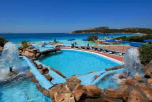 a swimming pool with water fountains at a resort at COLONNA GRAND HOTEL CAPO TESTA, a Colonna Luxury Beach Hotel, Santa Teresa Sardegna in Santa Teresa Gallura