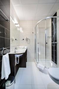 a bathroom with a shower and a sink and a tub at Hotel Trzebnica in Trzebnica