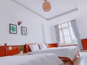 a bedroom with two beds and a window at VIỆT Hostel in Hue