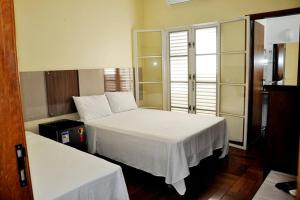 a bedroom with two beds with white sheets at Suítes La Cabana in Capitólio