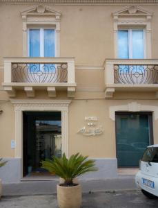 a building with balconies and a plant in front of it at Hotel Muraglie in Vibo Valentia