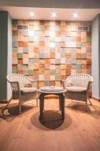 three chairs and a table in front of a wall at Star inn Peniche in Peniche
