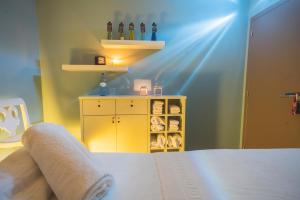 a bedroom with a bed and a yellow cabinet with wine bottles at Star inn Peniche in Peniche