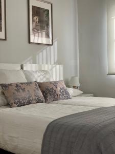 1 dormitorio con 1 cama con sábanas y almohadas blancas en Diamond Apartments Puerto De Malaga, en Málaga