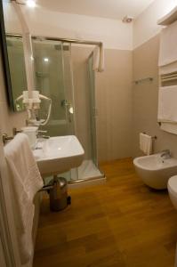 a bathroom with a sink and a shower and a toilet at Hotel Muraglie in Vibo Valentia