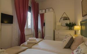 マドリードにあるApartamento Vive en Maravillasの小さなベッドルーム(ベッド2台、窓付)